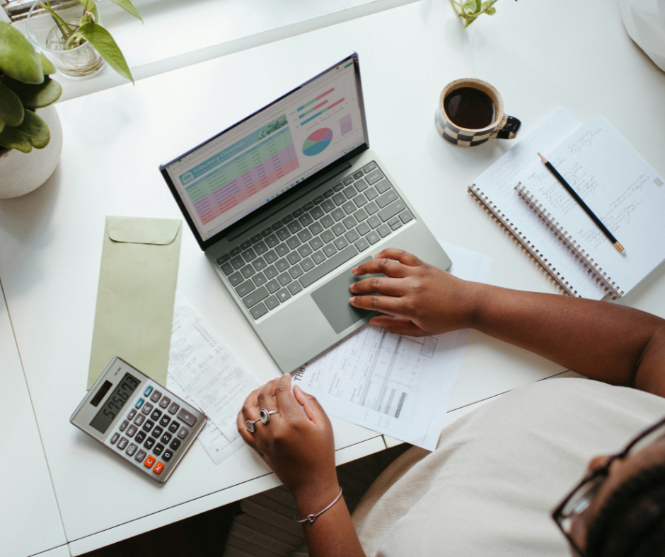 woman-using-laptop-next-to-calculator-in-excel